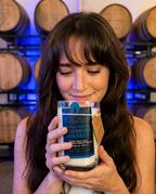 Model holding the Hollywood Distillery bourbon candle in the barrel room