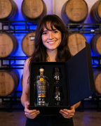 Model holding the Hollywood Distillery Oasis Vodka gift set box in the barrel room