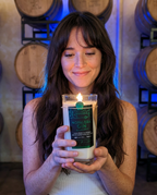 Model holding the lit Hollywood Distillery Gin candle in the barrel room