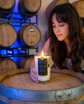 Model with the lit Hollywood Distillery Vodka candle on a barrel in the barrel room