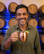 Man holding the Hollywood Distillery copper Moscow Mule mug in the barrel room