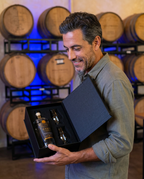 Man holding the Hollywood Distillery Oasis Vodka gift set in the barrel room